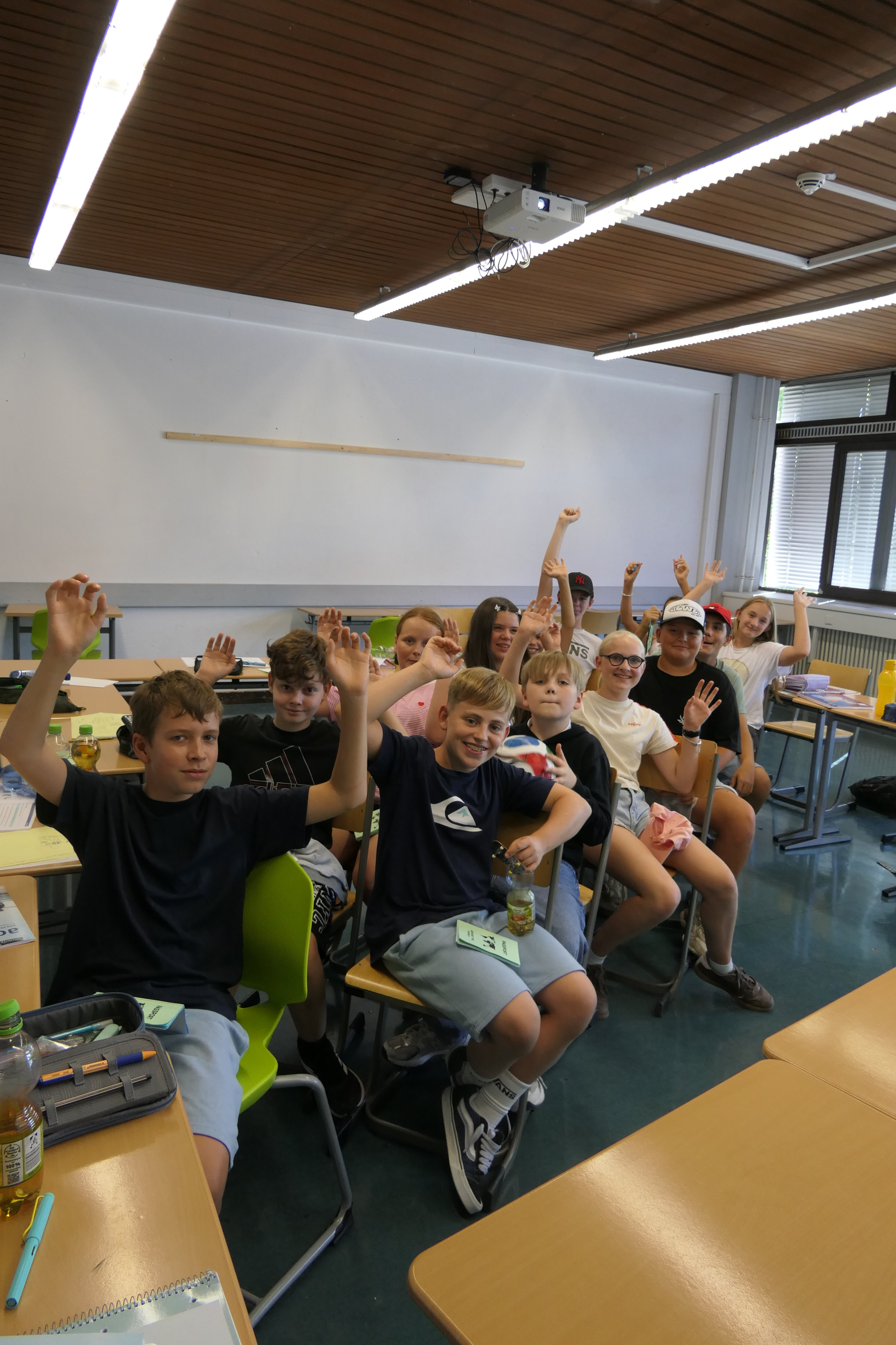 Schülergruppe mit erhobenen Händen