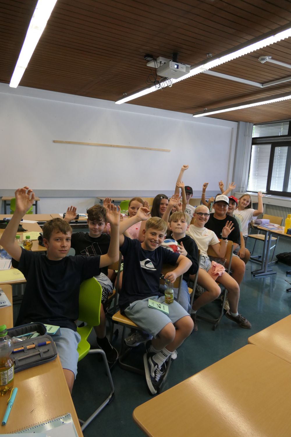 Schülergruppe mit erhobenen Händen