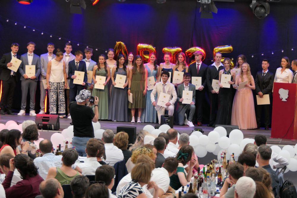 Abiturienten mit ihren Zeugnissen auf der Bühne