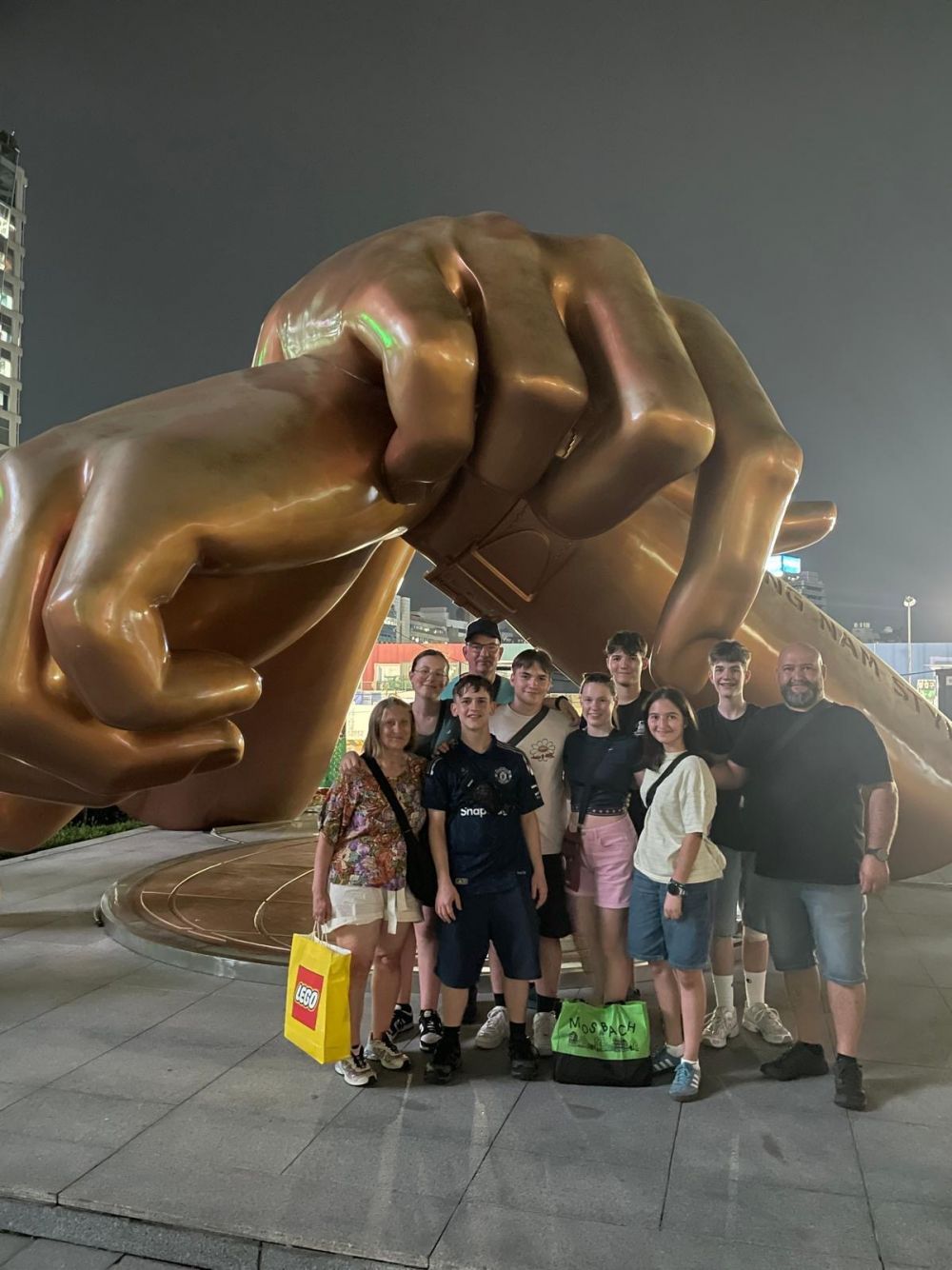 Beide Teams vor der Bronzeskulptur zweier Riesenhände