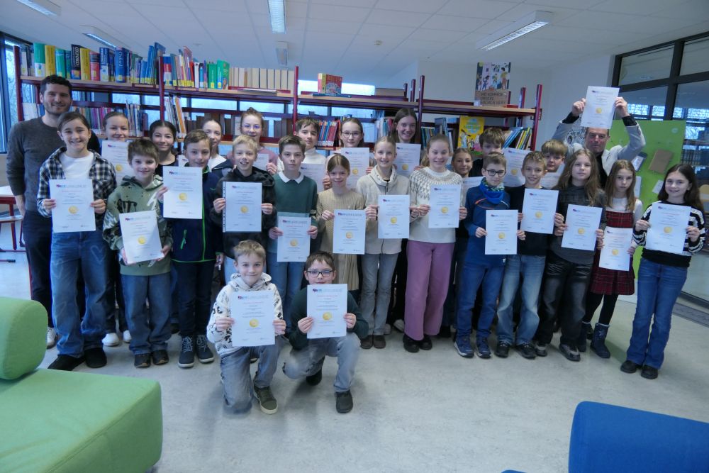 Das Foto zeigt einen Teil der Goldmedaillengewinner bei "Mathe im Advent" zusammen mit Schulleiter Dr. Pauer und Organisator Johannes Berberich.