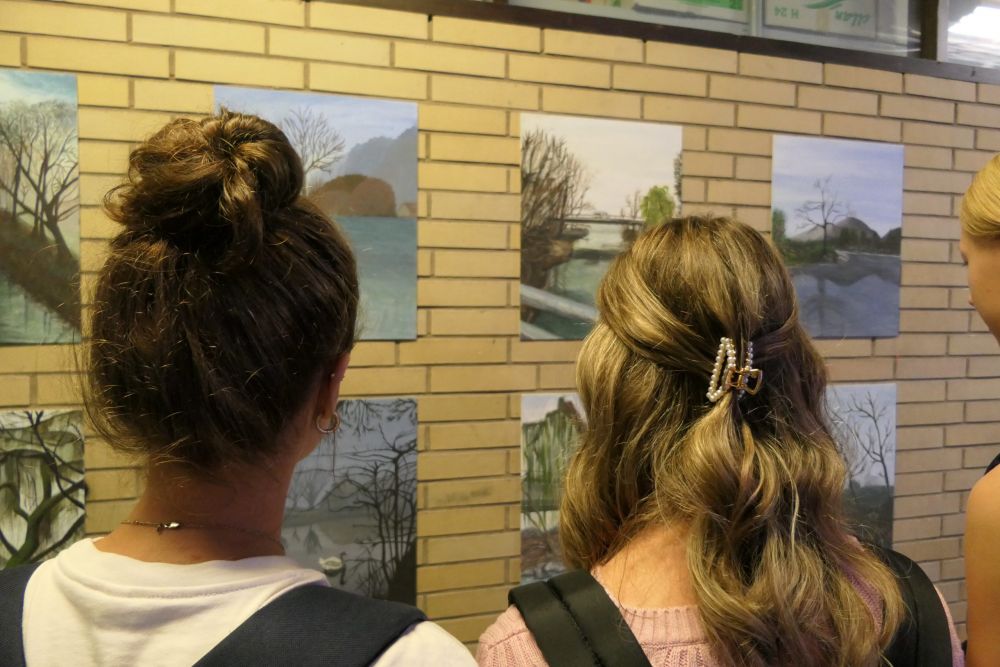 Schülerinnen betrachten die ausgestellte Kunst

