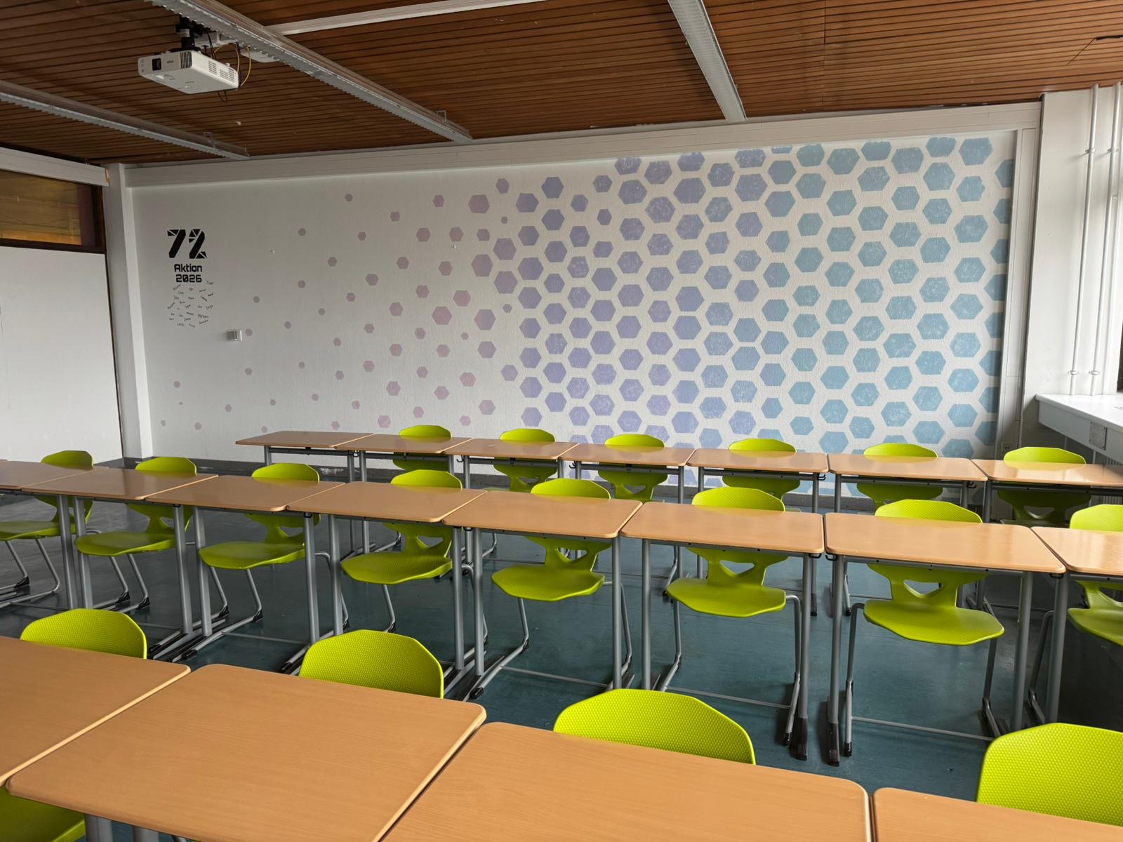 Die Rückwand des Klassenzimmers erstrahlt in klaren Farben.