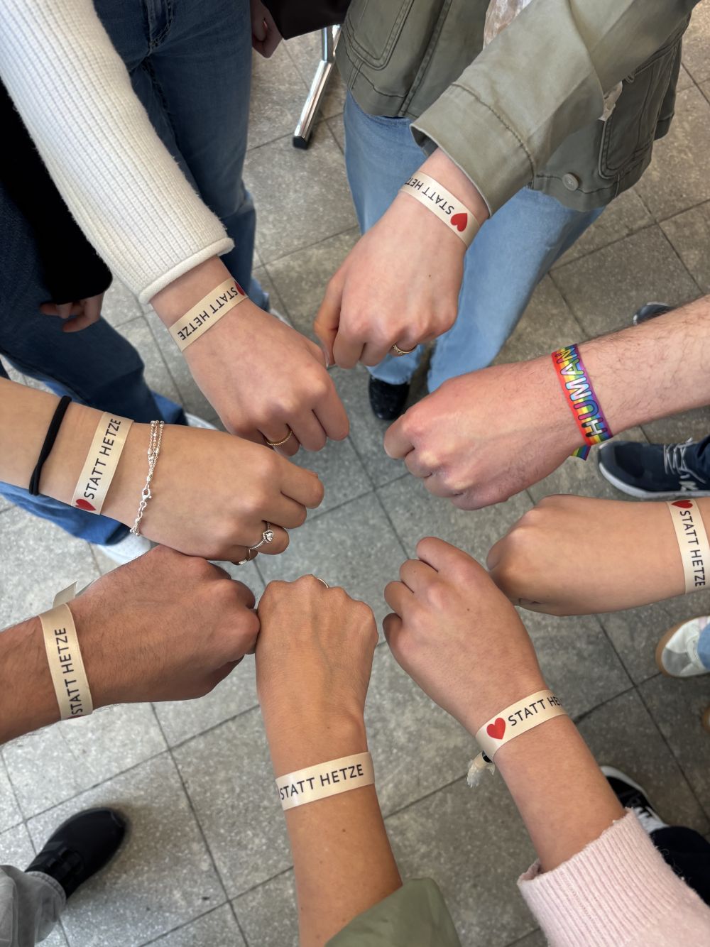 Herz statt Hetze - sieben Handgelenke mit Bändchen