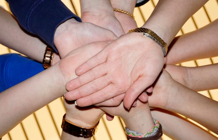 Viele Hände die in einem Kreis übereinander Liegen